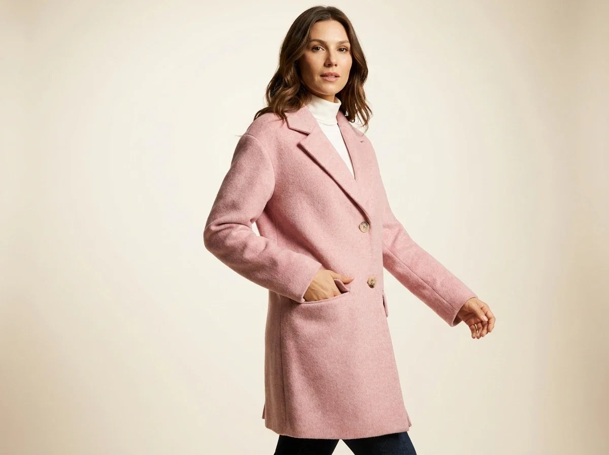 Brunette woman modeling a Charter Club blush pink wool-blend tailored coat over a white turtleneck in a studio setting.