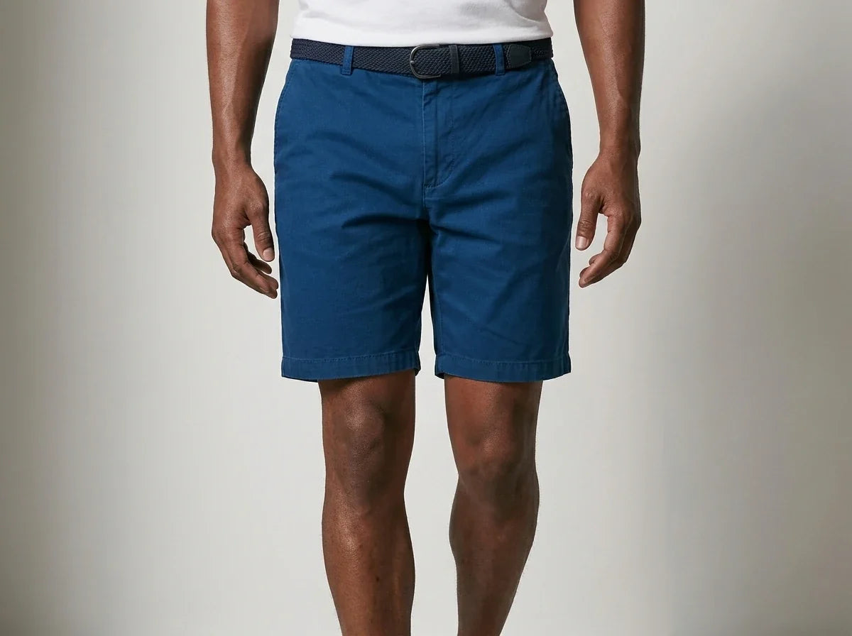 Front view of a man wearing classic teal blue chino shorts with a woven belt and white t-shirt.