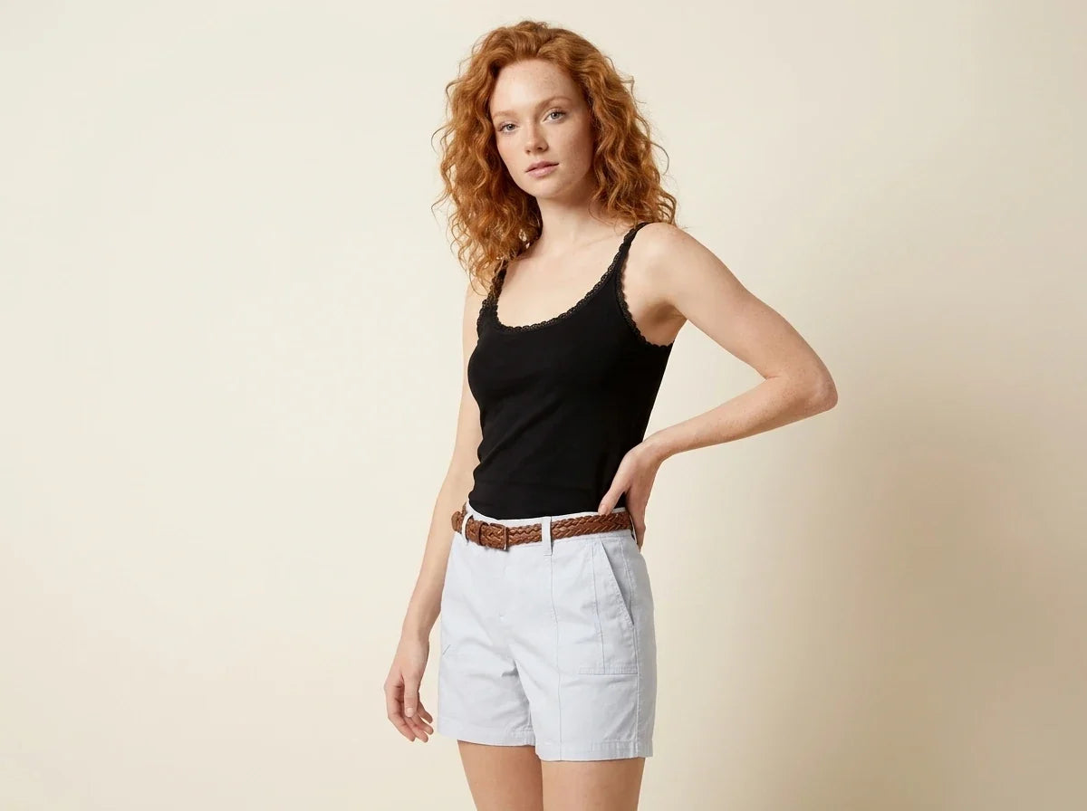Red-haired woman modeling a black lace-trim scoop neck tank top paired with light blue shorts and a brown braided belt[cite: 24].
