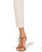 Tan open-toe sandal worn with a white pant on a white background