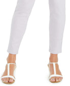 White sandals worn with light gray pants on a white background