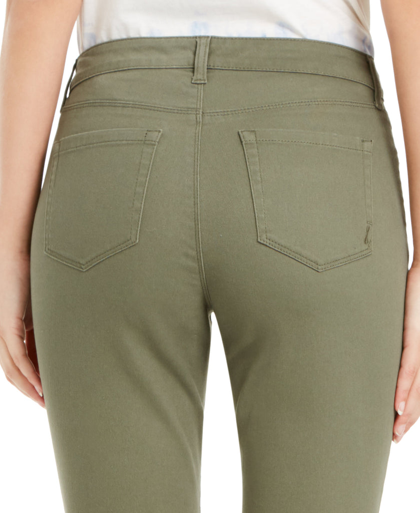 Close-up of olive green pants with a white shirt underneath on a plain background