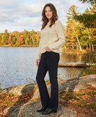 Woman standing by a lake with autumn foliage