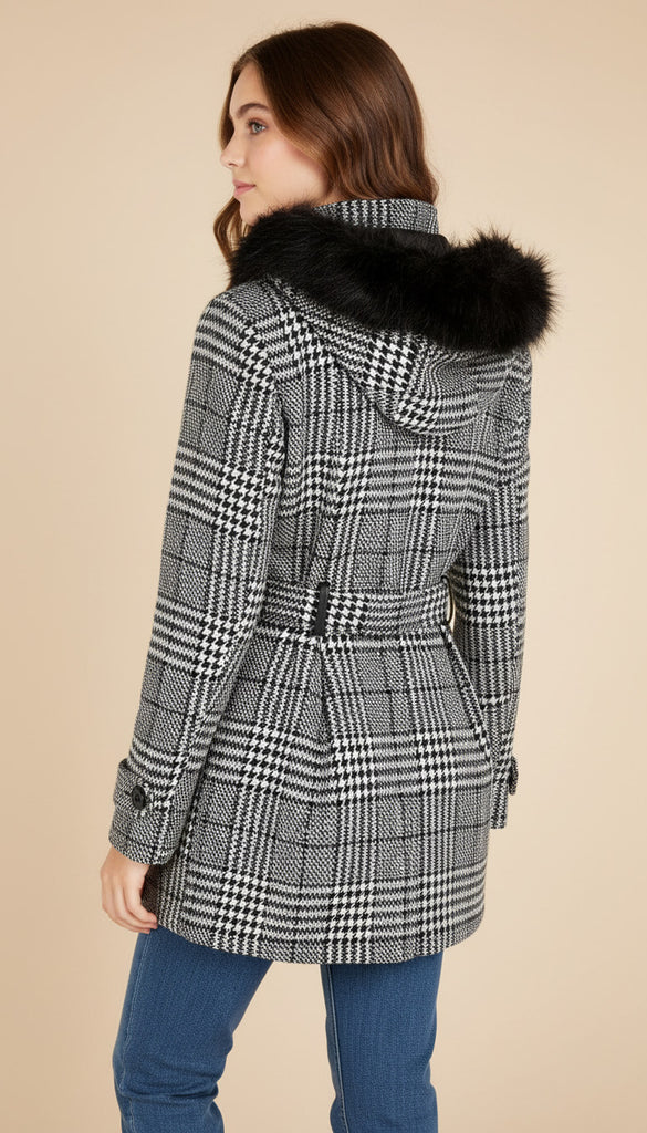 Teen wearing a checkered coat with a fur hood on a beige background