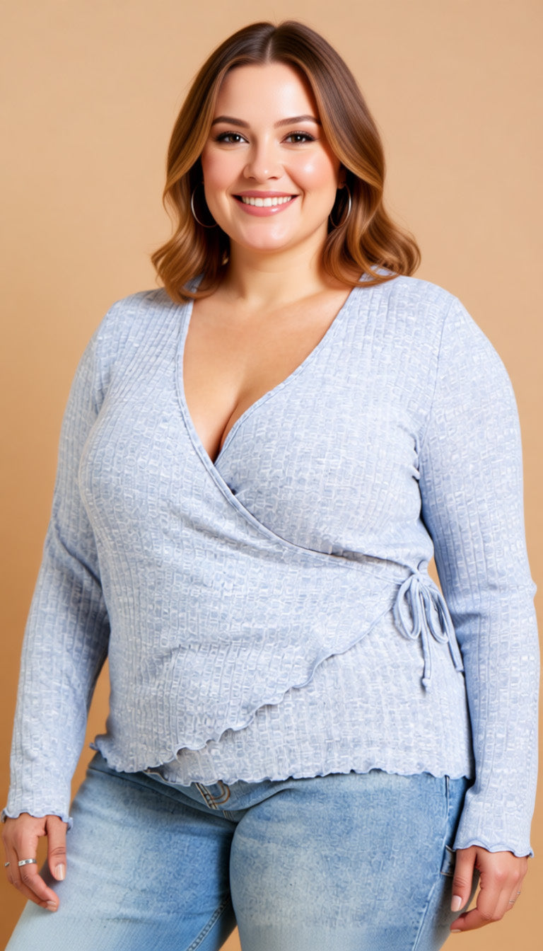Woman wearing a light blue wrap top and jeans against a beige background