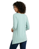 Woman wearing a light blue long-sleeve top on a white background
