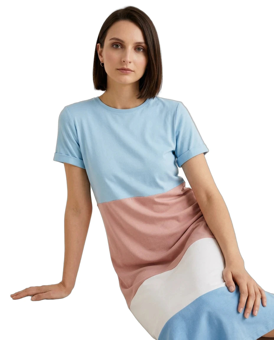 A woman wearing a color-block short-sleeve dress with light blue, dusty pink, and white panels, posed against a solid white background.