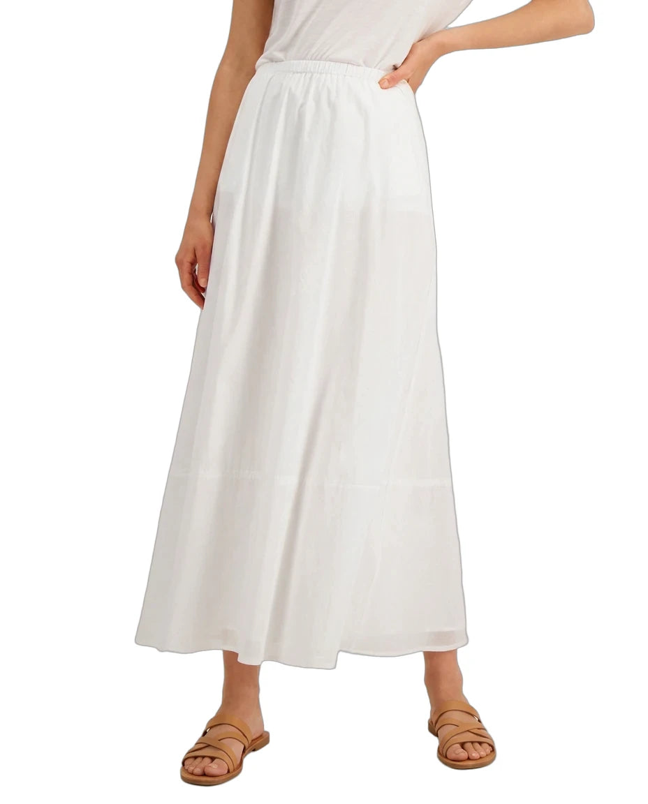 A model wearing a white midi skirt with a smocked waistband, paired with a white top and tan leather sandals, shown against a plain white background.