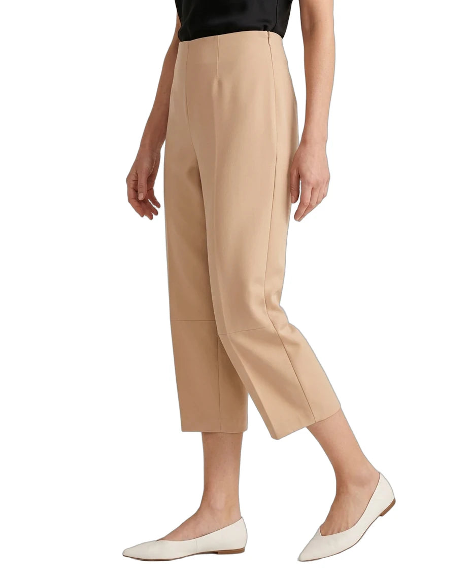 A model wearing beige cropped trousers with a black top and off-white pointed flats, shown from the waist down against a plain white background.