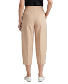 A model shown from the back wearing high-waisted, cropped, wide-leg trousers in a light beige color, paired with a black top and white slip-on shoes, against a plain white background.