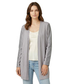Woman wearing a gray cardigan over a white top and blue jeans on a white background