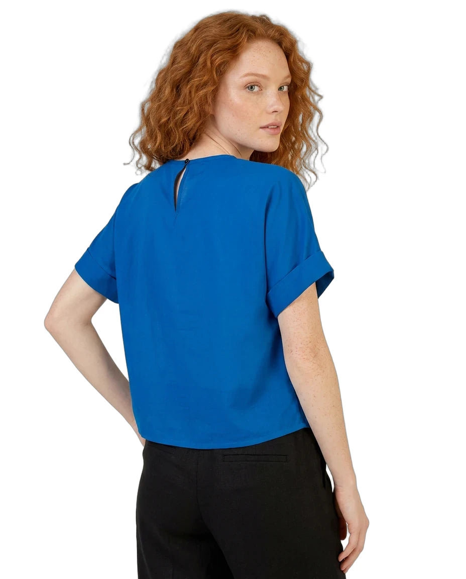 Woman wearing a blue top and black pants on a white background