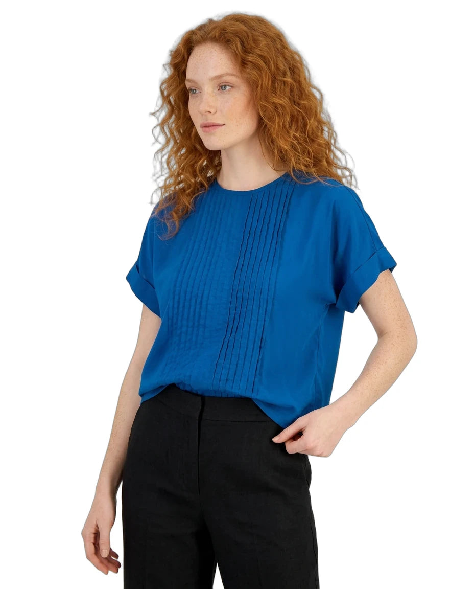 Woman wearing a blue top and black pants on a white background
