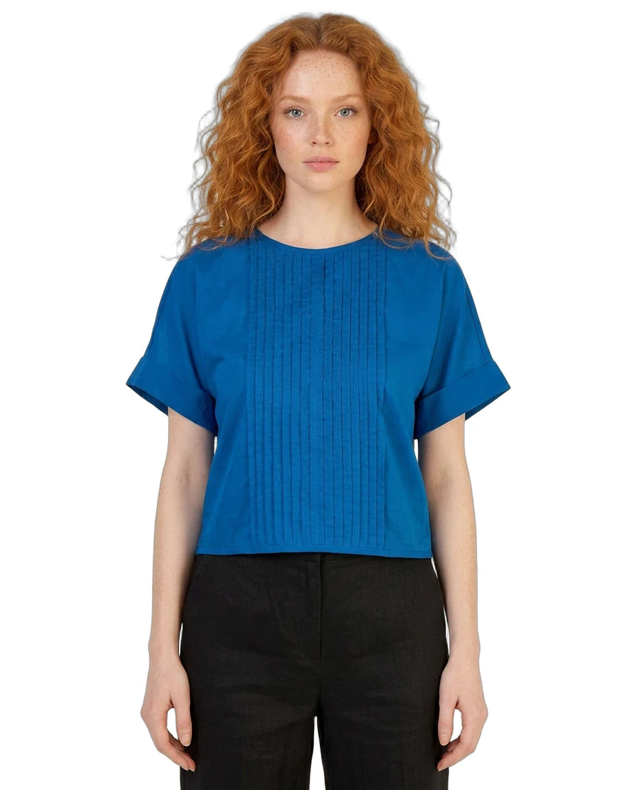 Woman wearing a blue top and black pants on a white background