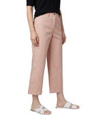 A model wearing dusty pink cropped pants, a black t-shirt, and white slide sandals, shown from the waist down against a plain white background.