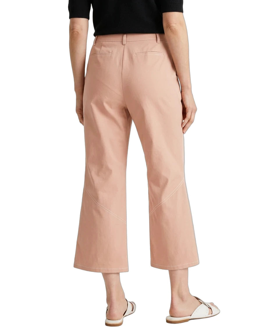 A model shown from the back wearing high-waisted, cropped wide-leg trousers in a dusty peach-pink color, paired with a black top and white slide sandals, against a plain white background.