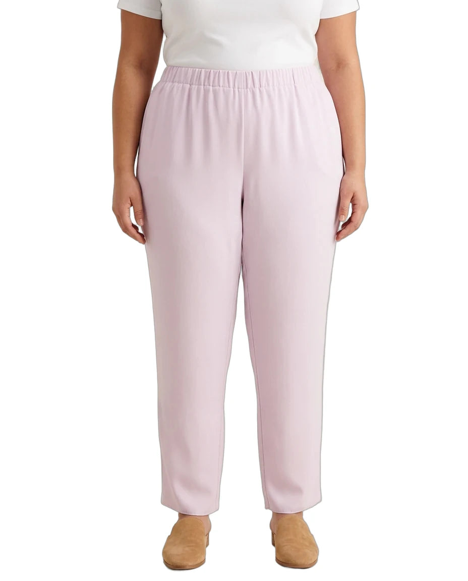 A model wearing light pink wide-leg cropped pants with an elastic waistband, paired with a white top and tan shoes, shown against a plain white background.
