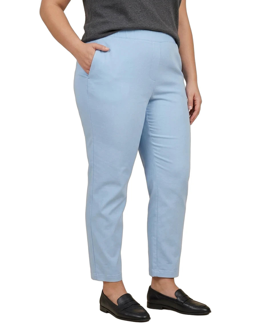A person wearing light blue cropped trousers with a dark gray top and black loafers, shown from the waist down against a plain white background.