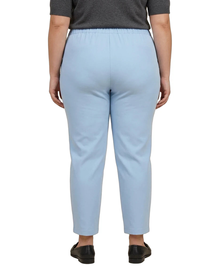 A person shown from the back wearing light blue cropped pants, a dark gray top, and black flats against a plain white studio background.