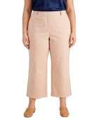 A model wearing a pair of light beige cropped wide-leg pants, paired with a navy top and tan flat shoes, shown against a plain white background.