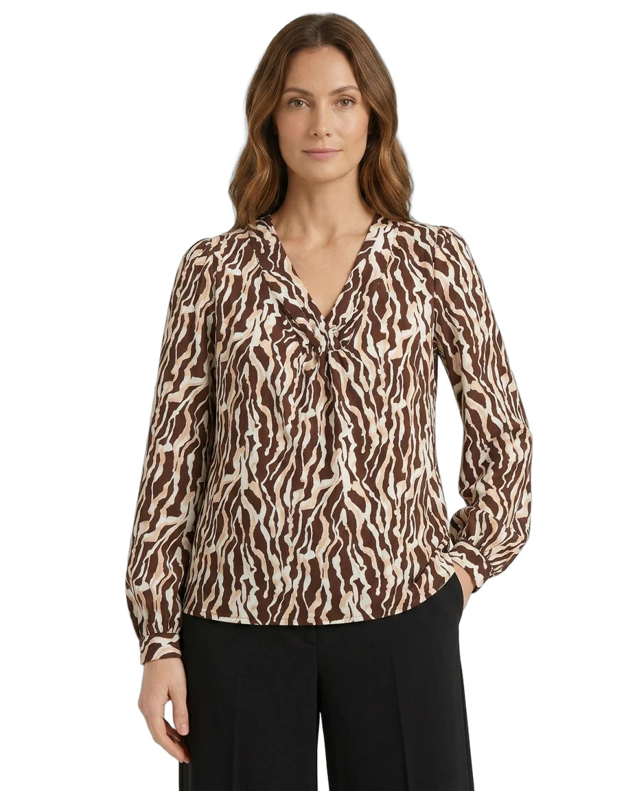 Woman wearing a brown and beige patterned blouse on a white background