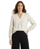 Woman wearing a white blouse with long sleeves on a white background