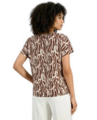 Woman wearing a zebra print top on a white background