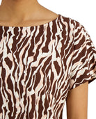 Close-up of a brown and beige zebra print top on a person.