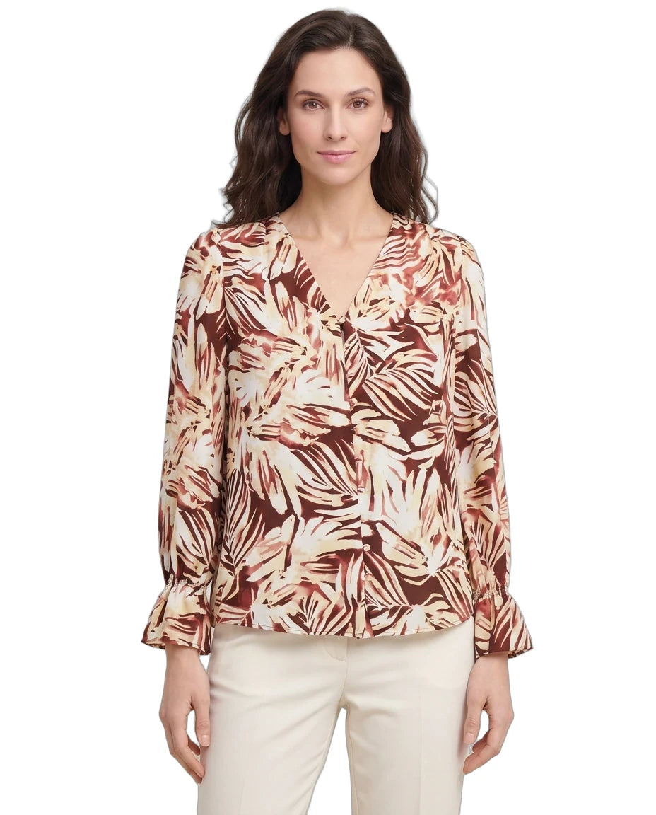 Woman wearing a patterned blouse on a white background