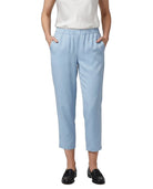 A model wearing light blue cropped trousers with an elastic waistband and side pockets, paired with a white top and black loafers, shown against a plain white background.