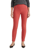 A model from the waist down wearing slim-fit coral red ankle-length pants, a dark gray long-sleeve top, and black flats, against a plain white background.