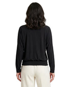 Person wearing a black long-sleeve top and white pants on a white background