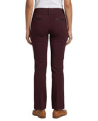 Rear view of a model wearing high-waisted, straight-leg trousers in a deep burgundy color, paired with a white top and brown shoes, against a plain white background.