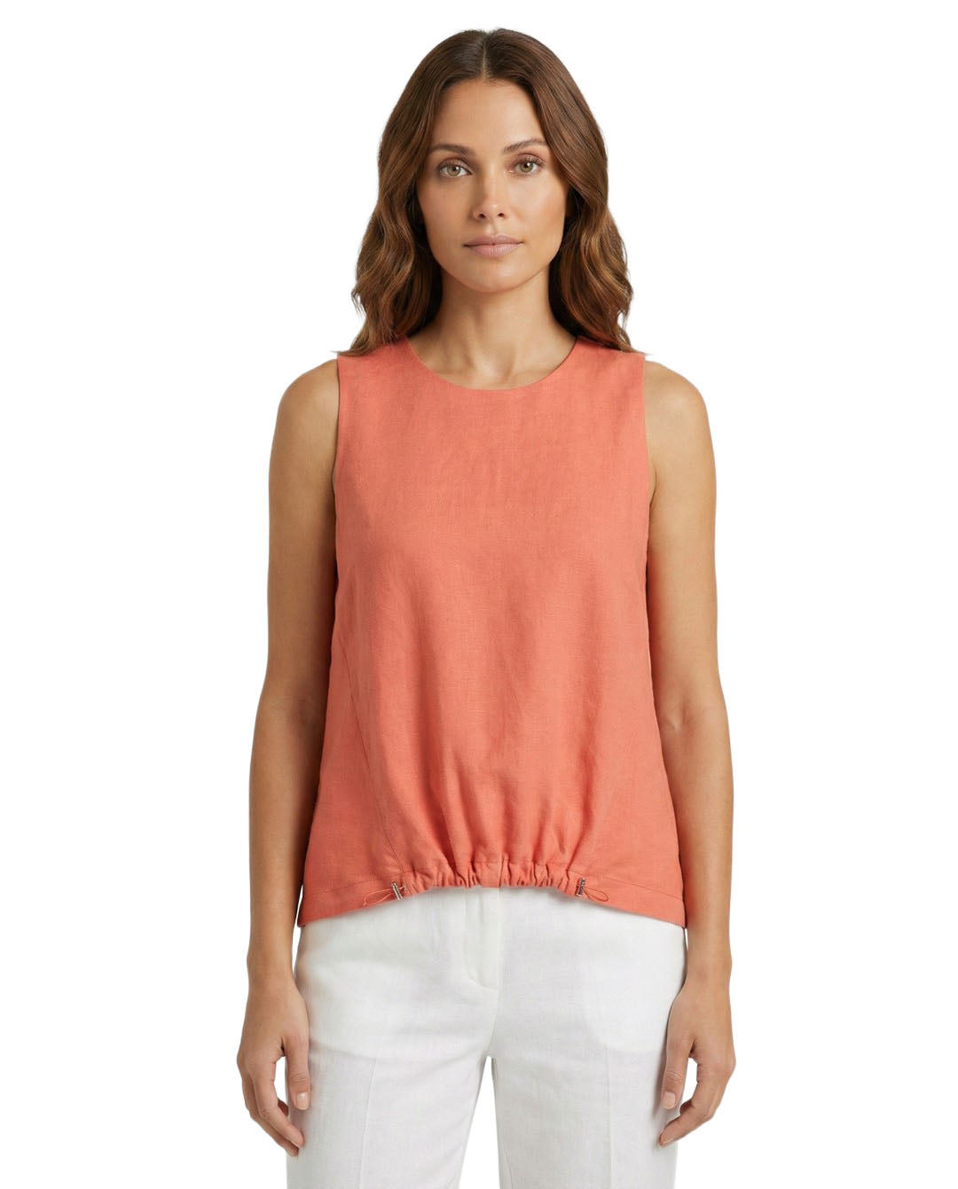 Woman wearing a coral sleeveless top and white pants on a white background