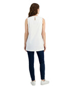 Woman wearing a white sleeveless top and dark blue pants on a white background