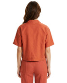 Person wearing an orange shirt and pants on a white background