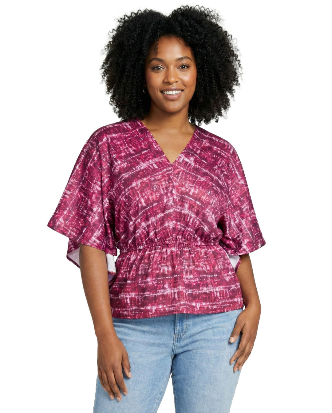 Woman wearing a pink tie-dye top and light blue jeans on a white background