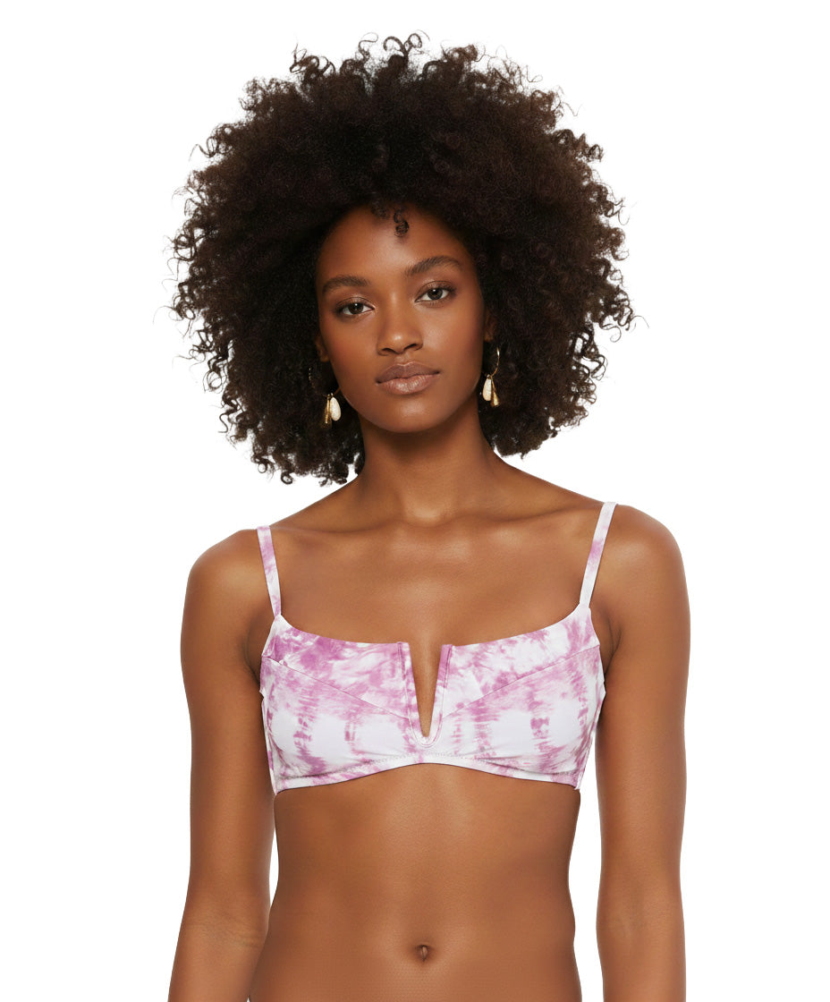 Woman wearing a pink tie-dye bikini top on a white background