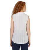 Woman wearing a white sleeveless Calvin Klein blouse with a subtle pattern on a white background