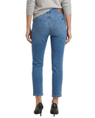 Blue jeans worn by a person on a white background