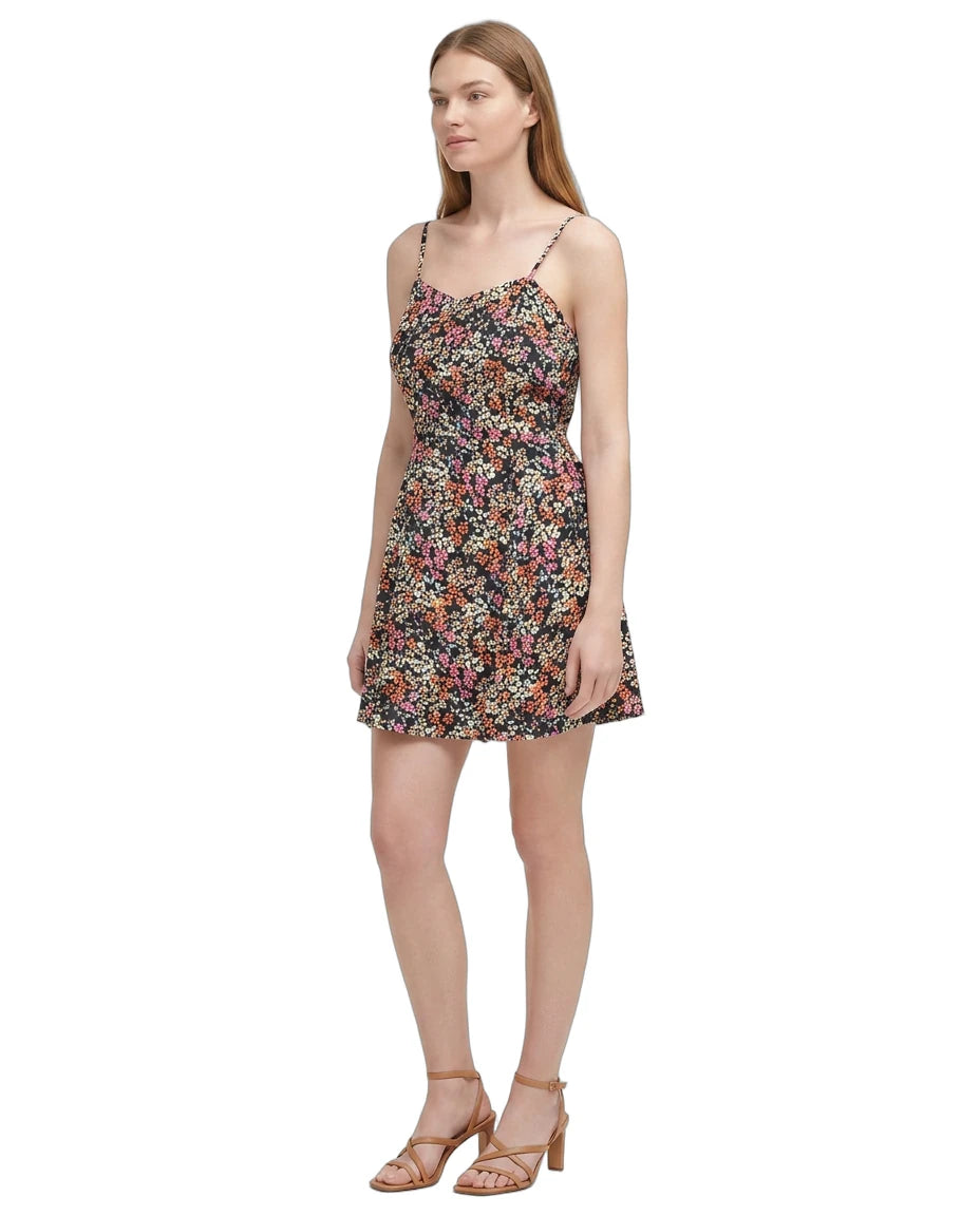 Woman wearing a floral Calvin Klein dress on a white background