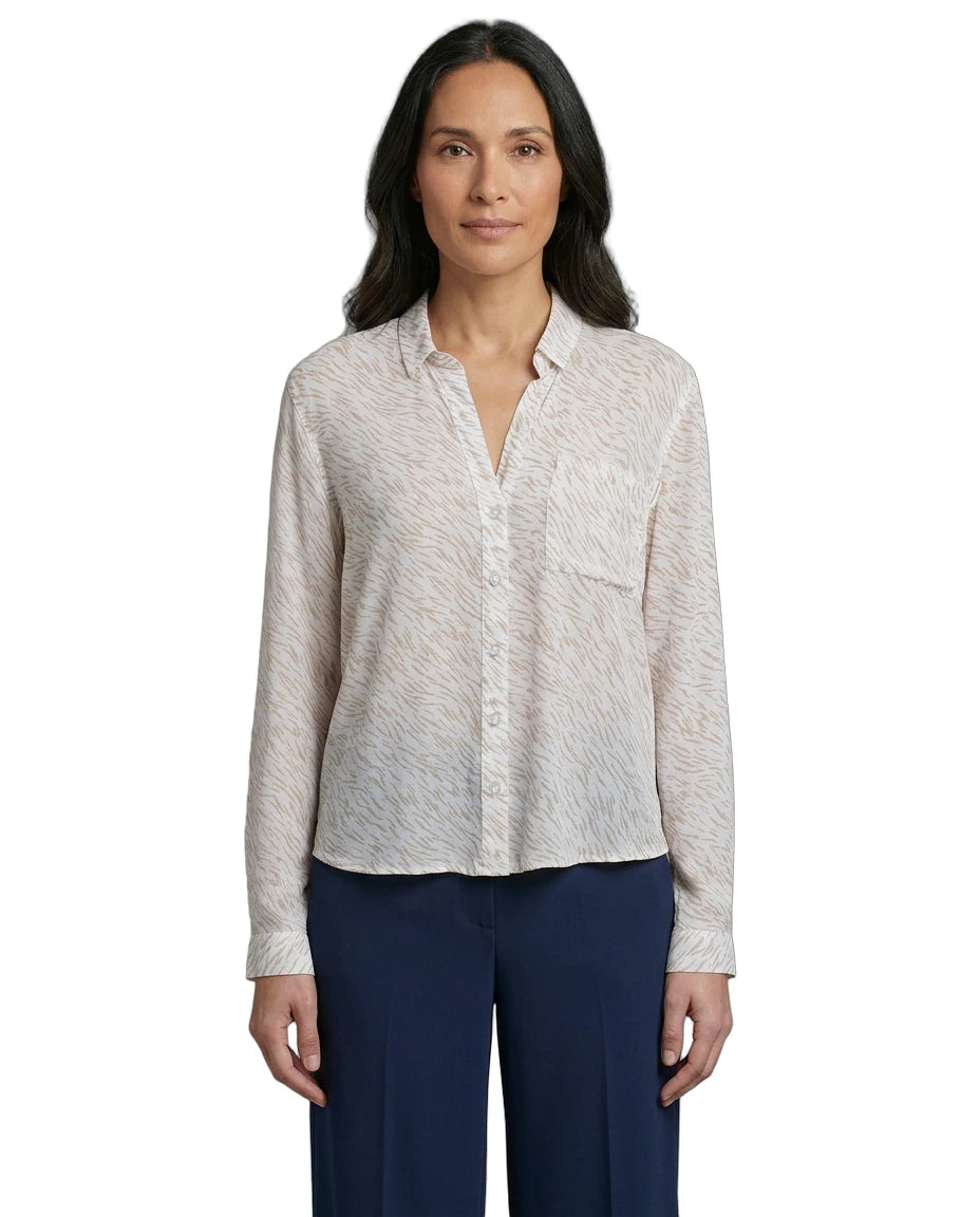 Woman wearing a light patterned Calvin Klein shirt and dark pants on a white background