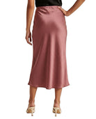 Person wearing a pink satin Calin Klein skirt on a white background