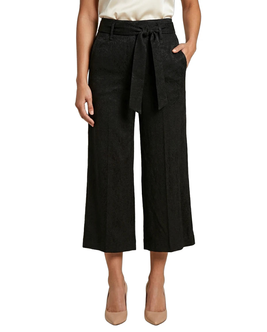 Black Calvin Klein wide-leg pants with a belt worn by a person on a white background