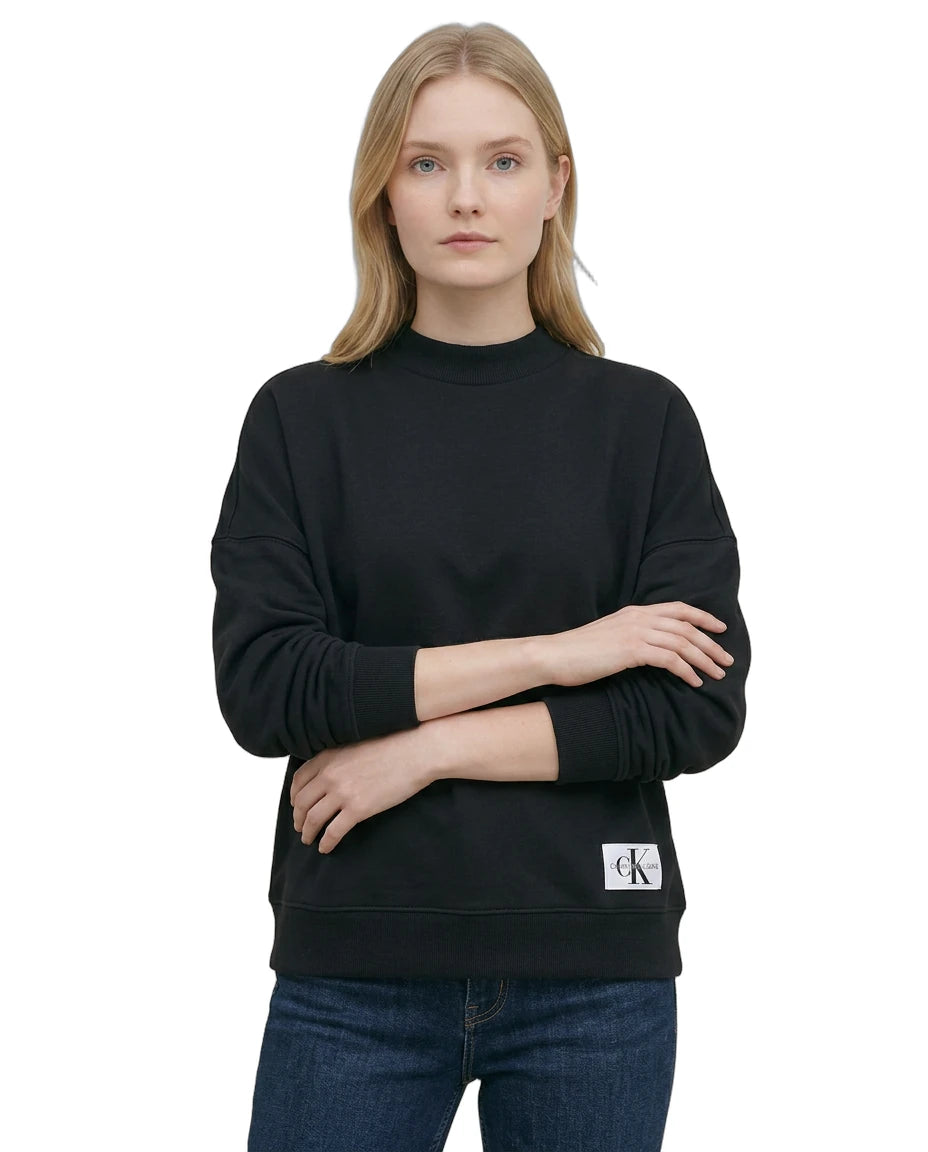 Woman wearing a Calvin Klein black sweatshirt with a brand logo on a white background