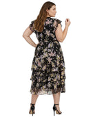 Woman wearing a black Calvin Klein floral dress on a white background