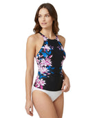 Woman wearing a floral Calvin Klein tankini top and white bottoms on a white background