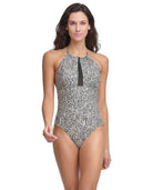 Woman wearing a black and white patterned Calvin Klein one-piece swimsuit on a white background
