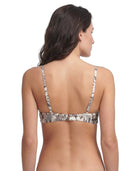 Woman wearing a patterned Calin Klein bikini top on a white background