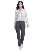 Woman wearing a checkered Calvin Klein shirt and gray pants on a white background